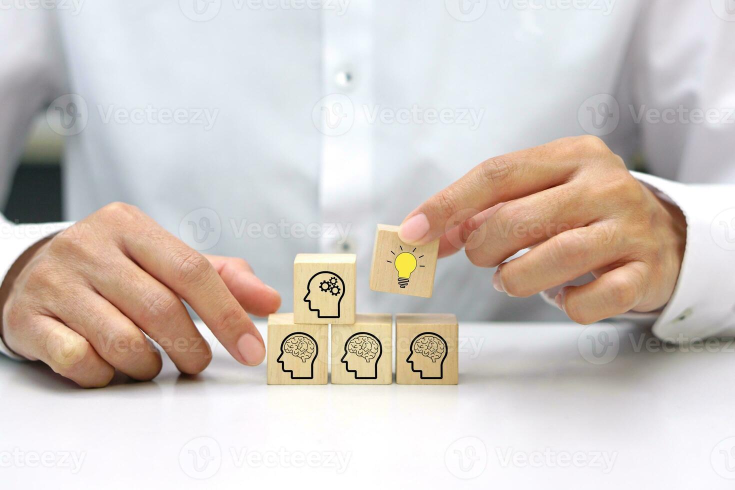 hölzern Blöcke mit Kopf Mensch Symbol vereinbart worden im Treppe Form, Hand halt hölzern Würfel Block mit Licht Birne Symbol Symbol. Brainstorming oder innovativ Idee Konzept. foto