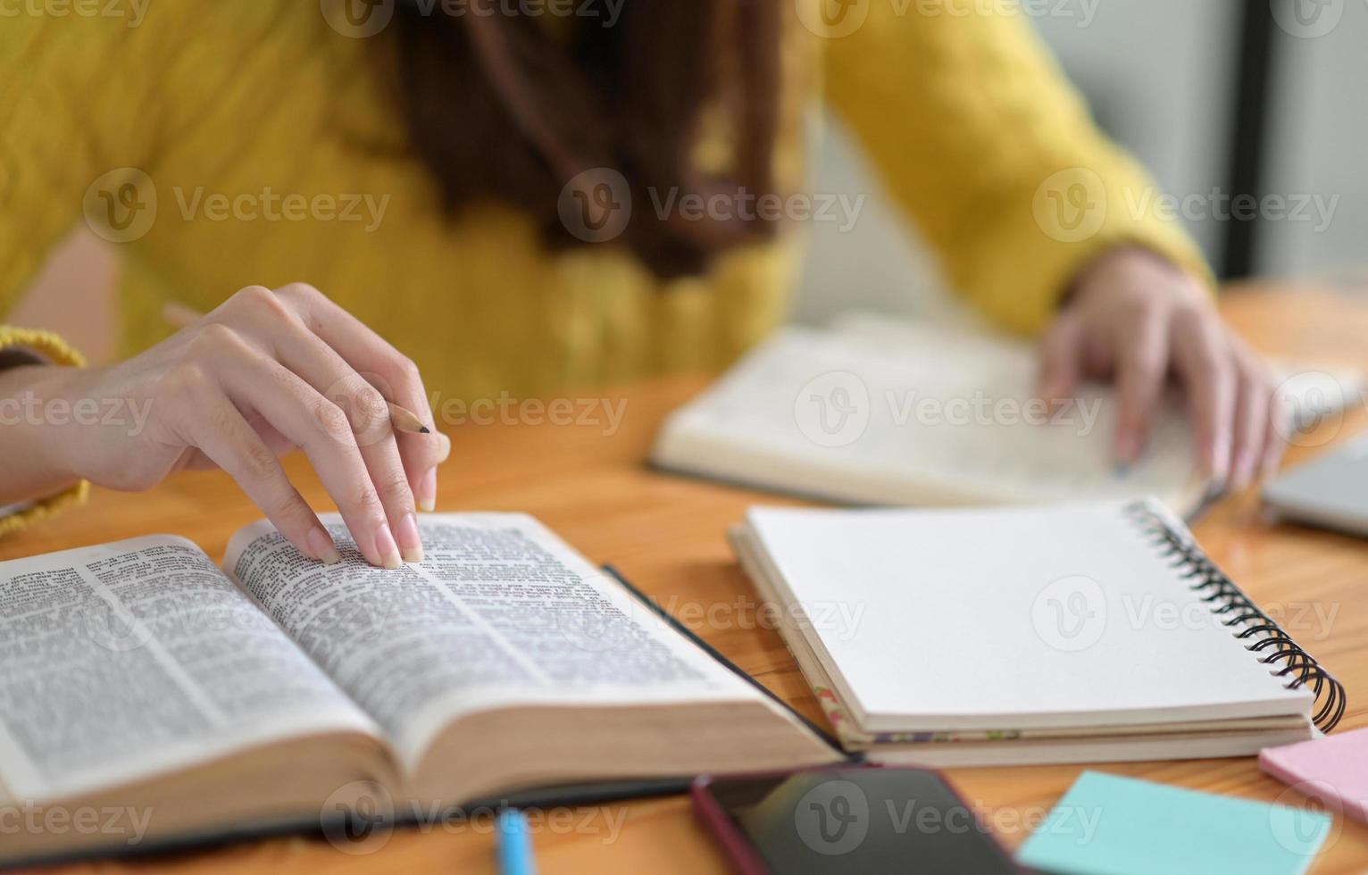 Nahaufnahme von jungen Frauen in gelber Kleidung, die Bücher lesen, um sich auf die Aufnahmeprüfungen für das College vorzubereiten. foto