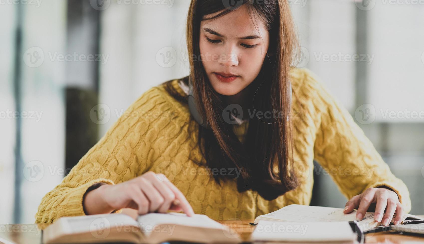 Ein junges Mädchen liest aufmerksam ein Buch, um sich auf eine Prüfung vorzubereiten. foto