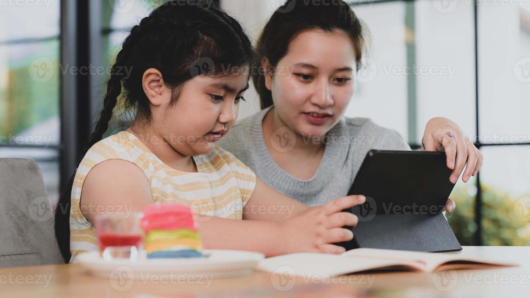 junge asiatische Mädchen Geschwister auf der Suche nach Tablet, zwei asiatische Mädchen mit Tablet. foto