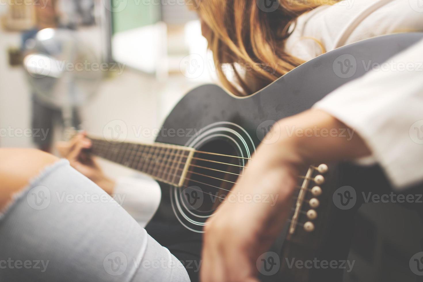 Akustikgitarrendetails in der Hand einer Linkshänderin foto