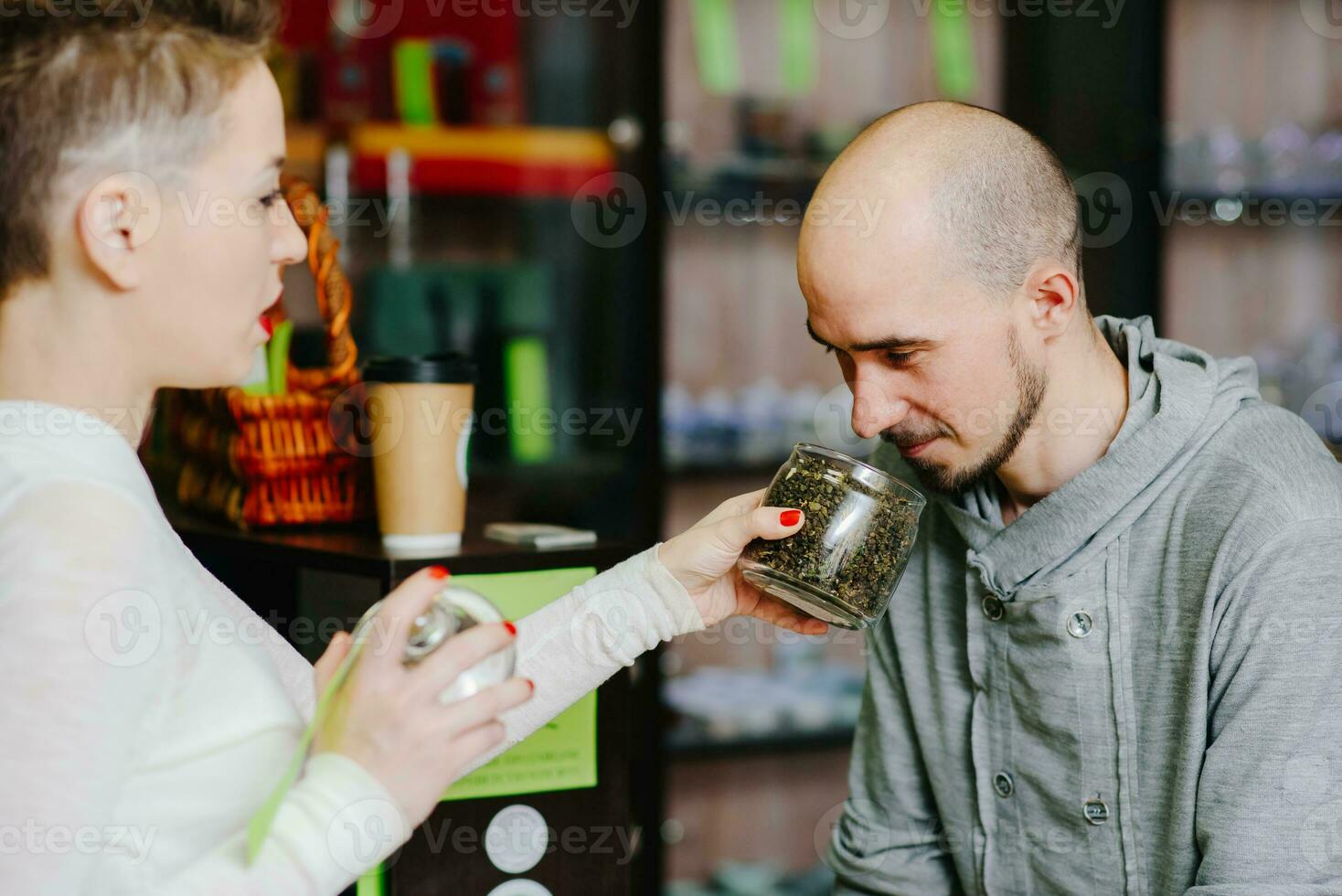 das Verkäufer bietet an zu Geruch Tee zu das Klient foto