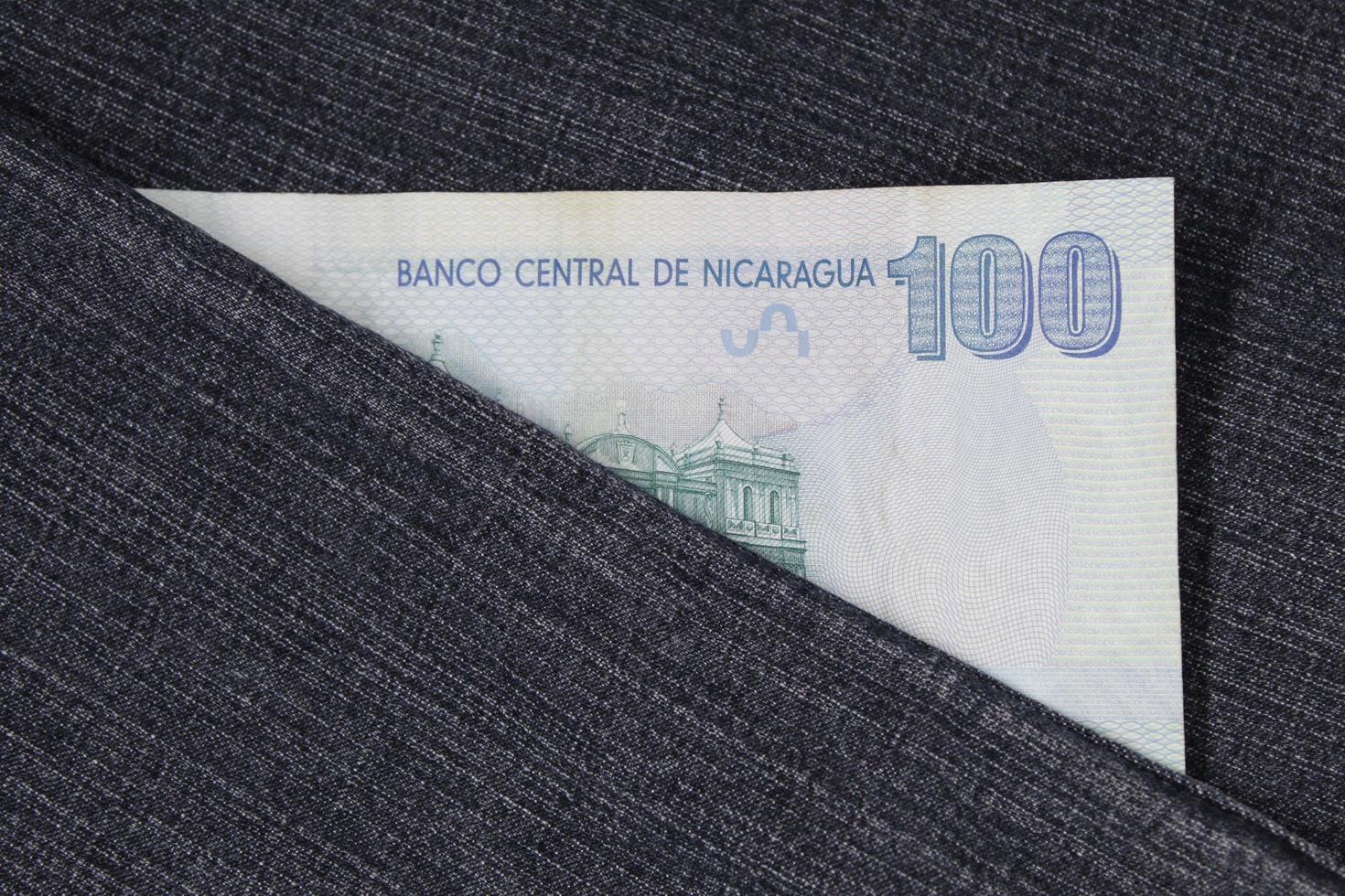 nicaraguanische Banknote von 100 Cordobas zwischen blauem Denim-Stoff foto