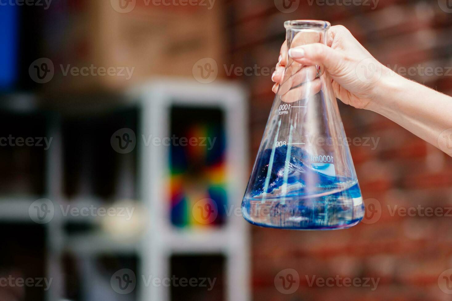 Wissenschaftler zeigt an Wie chemisch Elemente reagieren im ein Flasche mit Blau Vitalität foto