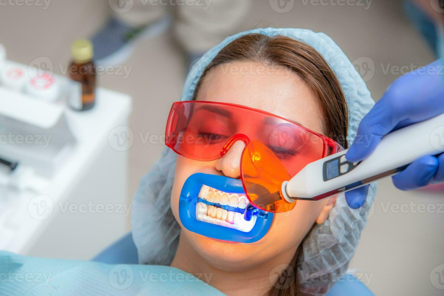 vorbereiten das Oral Hohlraum zum Bleaching mit ein ultraviolett Lampe. Nahansicht foto