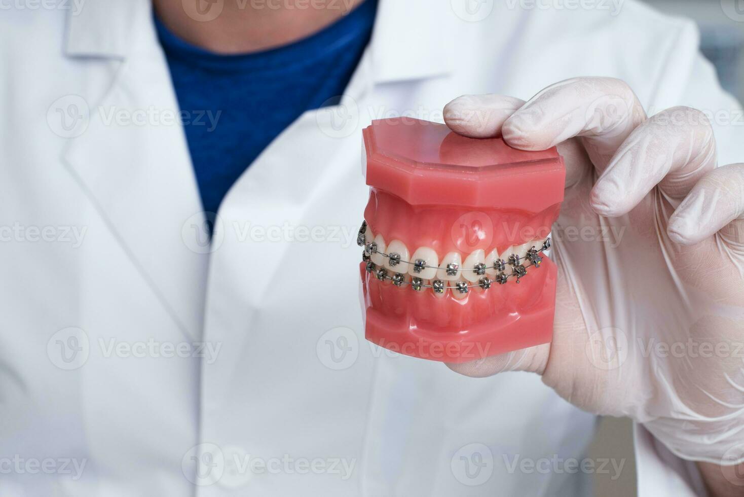 Arzt Kieferorthopäde zeigt an Wie das System von Hosenträger auf Zähne ist vereinbart worden foto