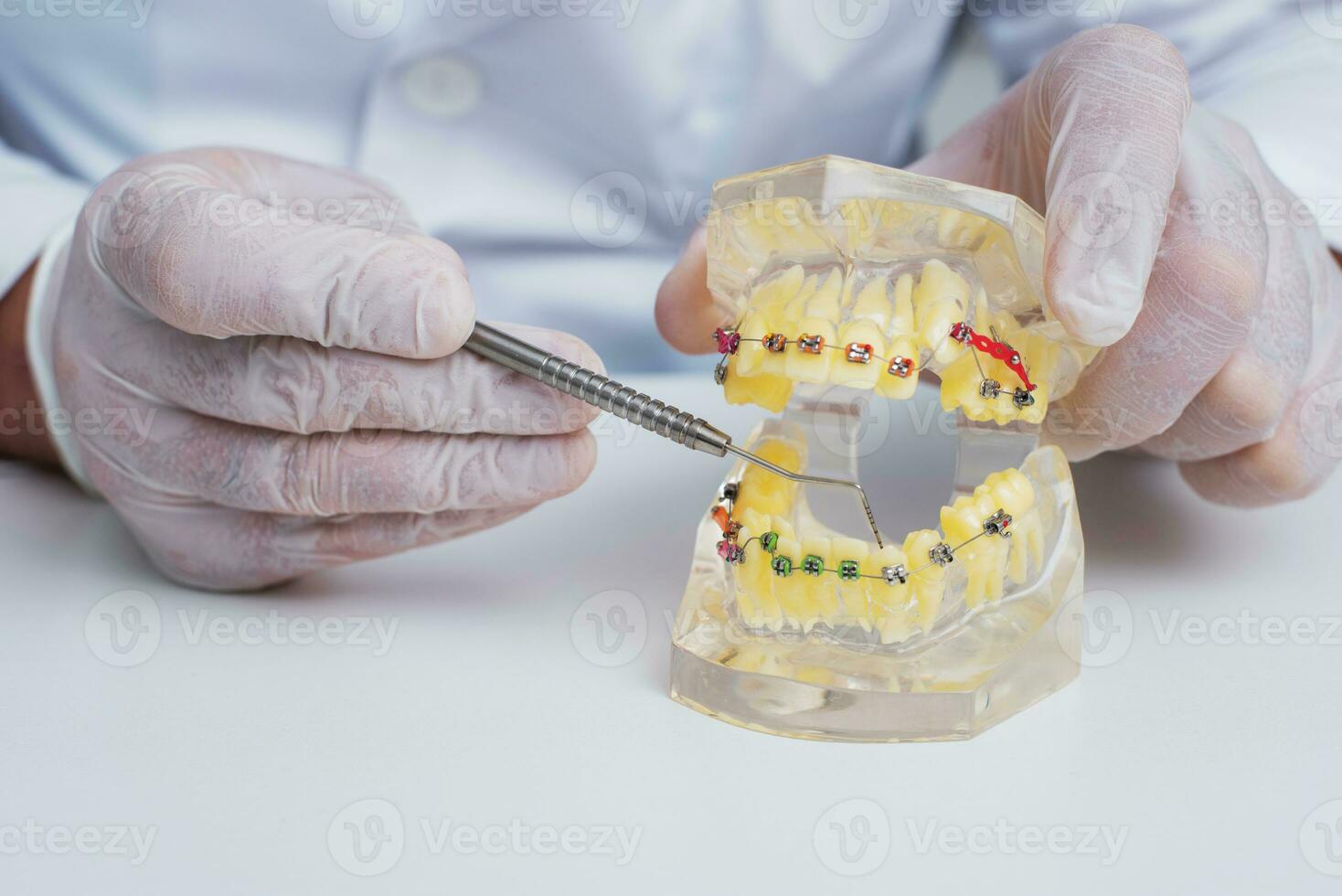 Arzt Kieferorthopäde zeigt an Wie das System von Hosenträger auf Zähne ist vereinbart worden foto