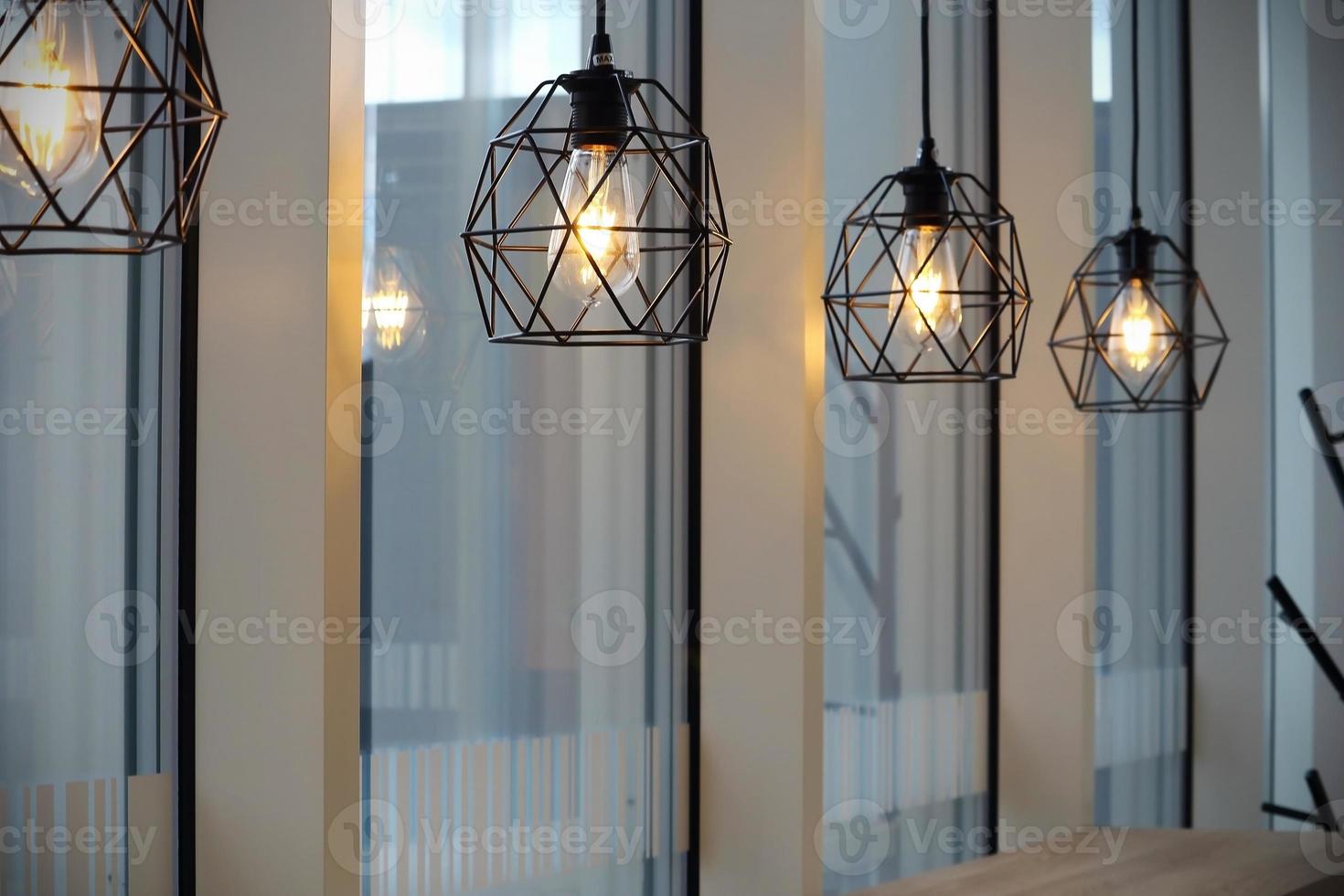 moderne Café-Schwarzmetallkarkassenlampen in der Nähe von Fenstern foto