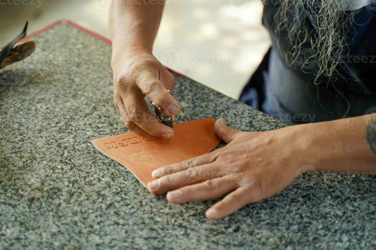 Nahansicht Hand von Leder Handwerker ist vorsichtig zu machen ein Leder Produkt zum ein Kunde., Leder Handwerker Konzept. foto