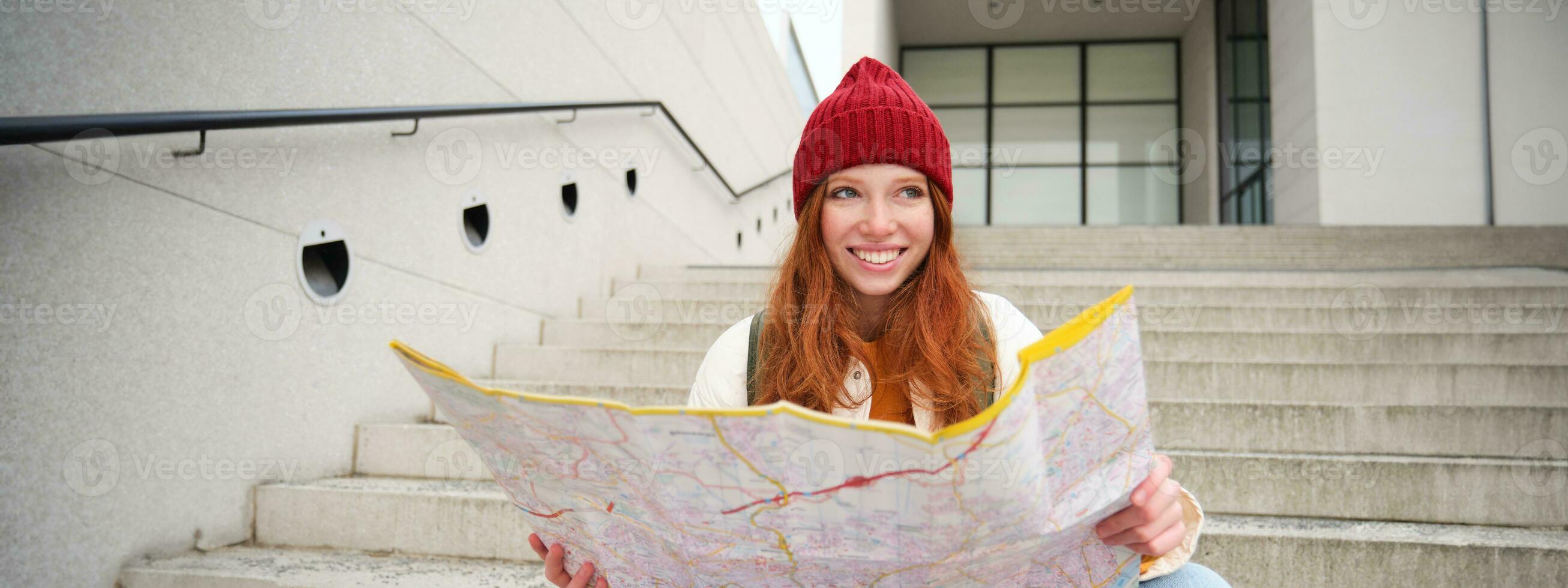 schön Mädchen Tourist sitzt auf Treppe mit Stadt Karte, Pläne ihr Reise, sieht aus zum Richtung während Reisen um Stadt, sucht Route zum Besichtigung foto