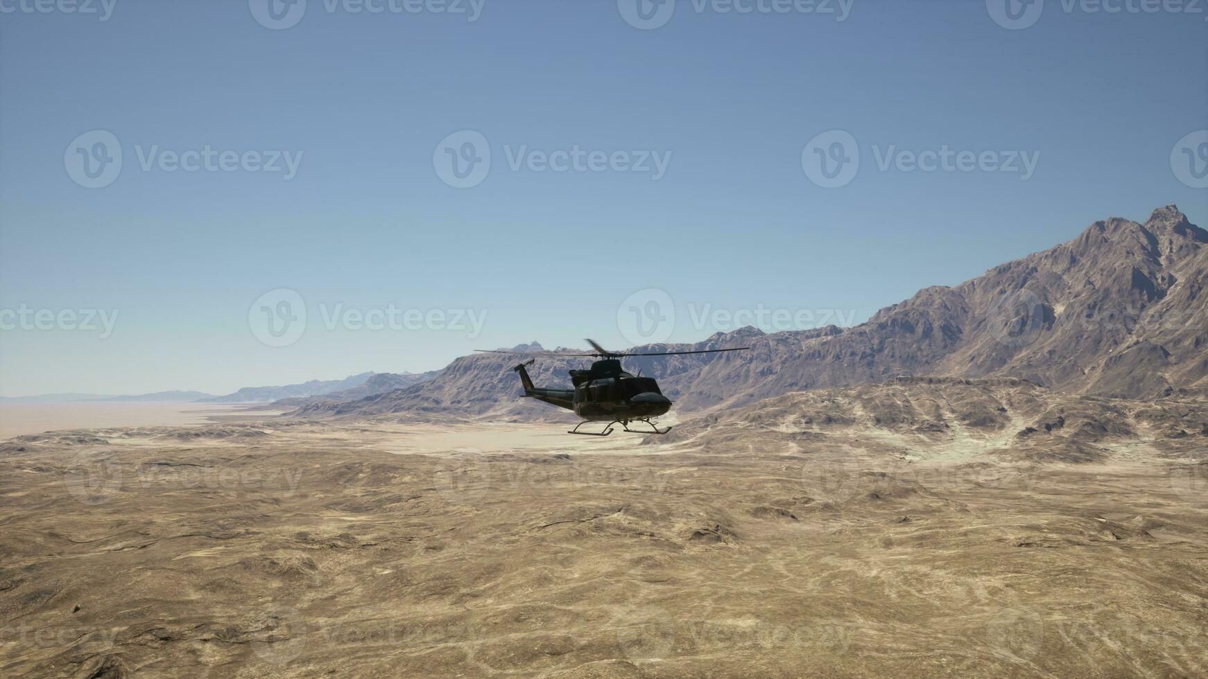 ein Hubschrauber fliegend Über ein Wüste Landschaft mit Berge im das Hintergrund foto