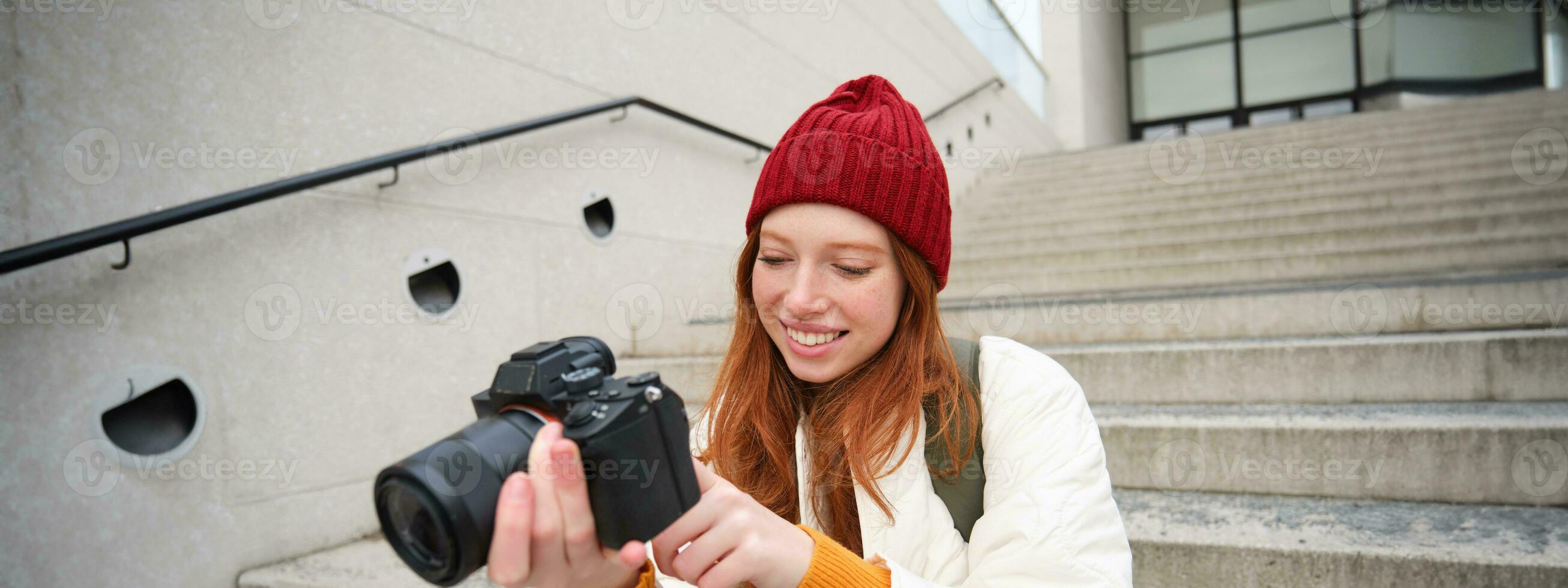 Porträt von weiblich Fotograf Gehen um Stadt mit Fachmann Kamera, nehmen Bilder Erfassen städtisch Schüsse, Fotografieren draußen foto