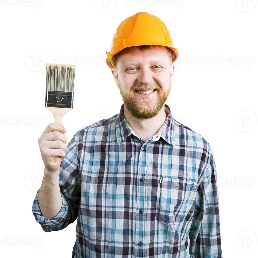 Mann in einem orangefarbenen Helm mit einer Bürste foto