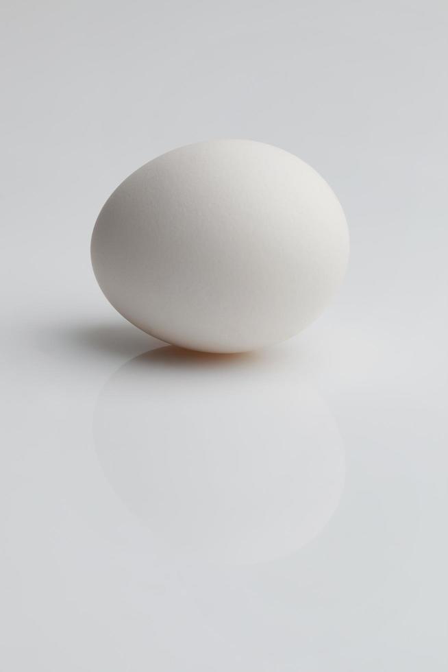 weißes Ei liegt auf hellem Hintergrund foto