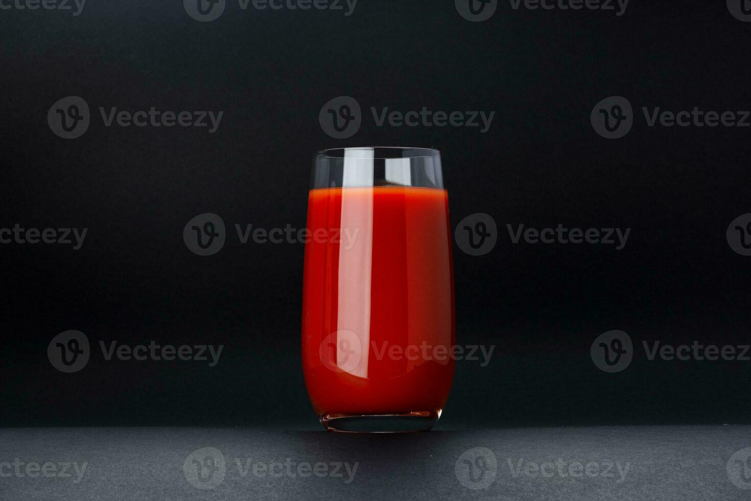 Glas von Tomate Saft isoliert auf schwarz Hintergrund mit Kopieren Raum foto