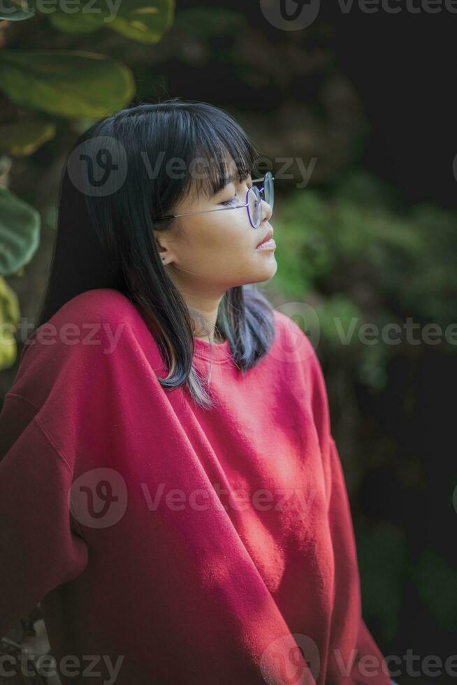 Porträt von asiatisch Teenager tragen Brille Stehen draussen foto