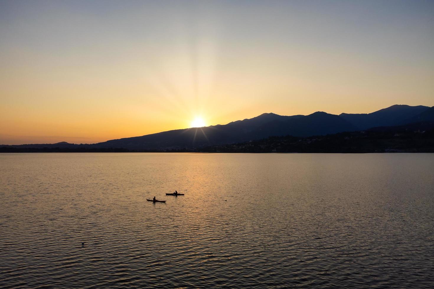 Silhouette von zwei Kajaks mitten im See bei Sonnenuntergang foto
