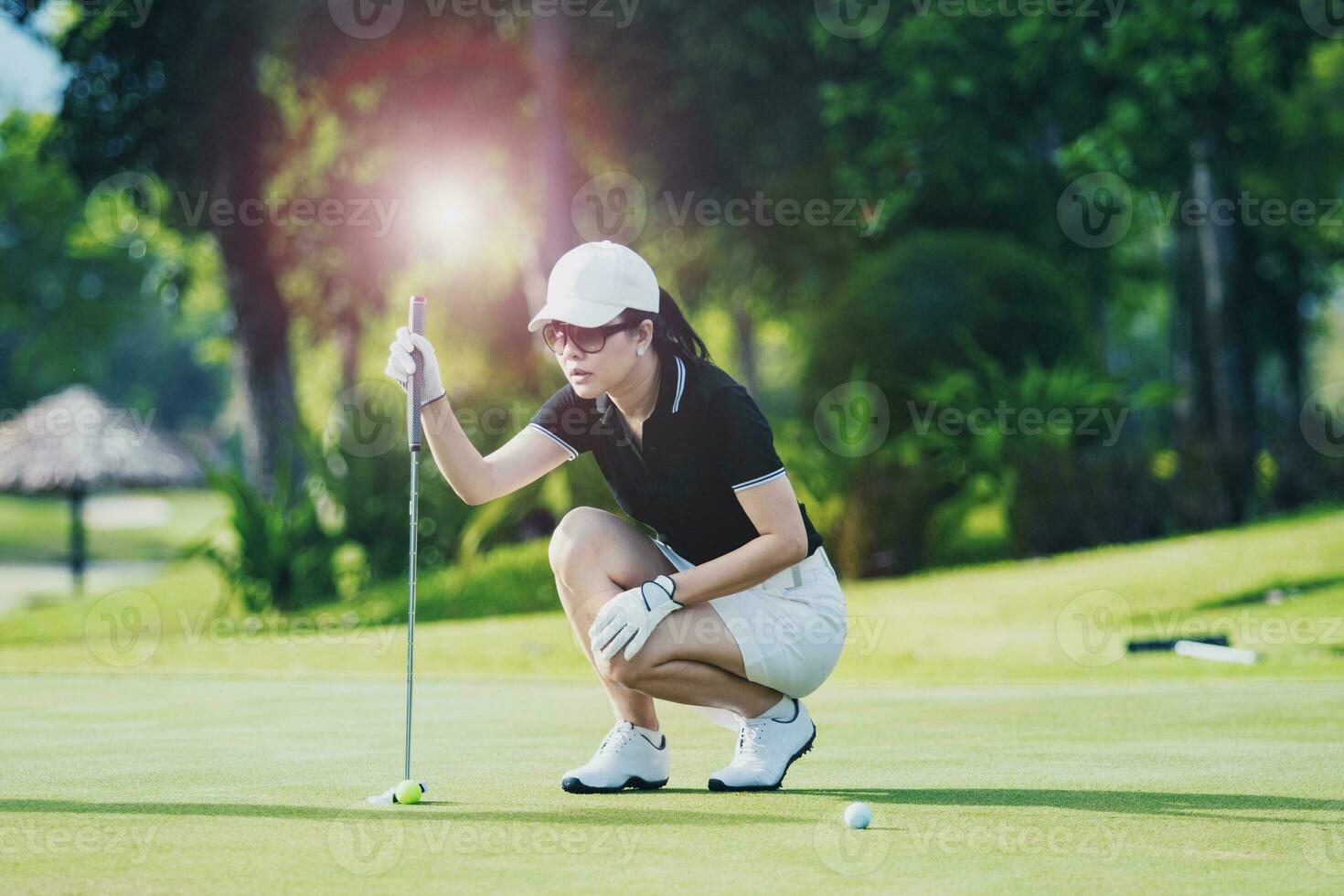 Frau Ansatz zum suchen Golf stellen Schuss auf Grün Golf Loch foto