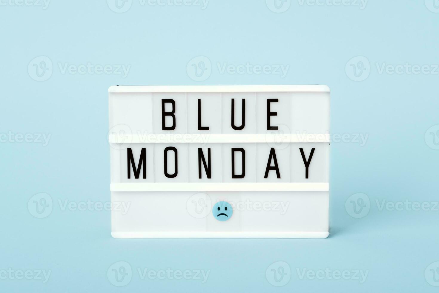 Blau Montag Konzept. Licht Tafel mit Blau Montag Text und traurig Gesicht auf Blau Hintergrund foto