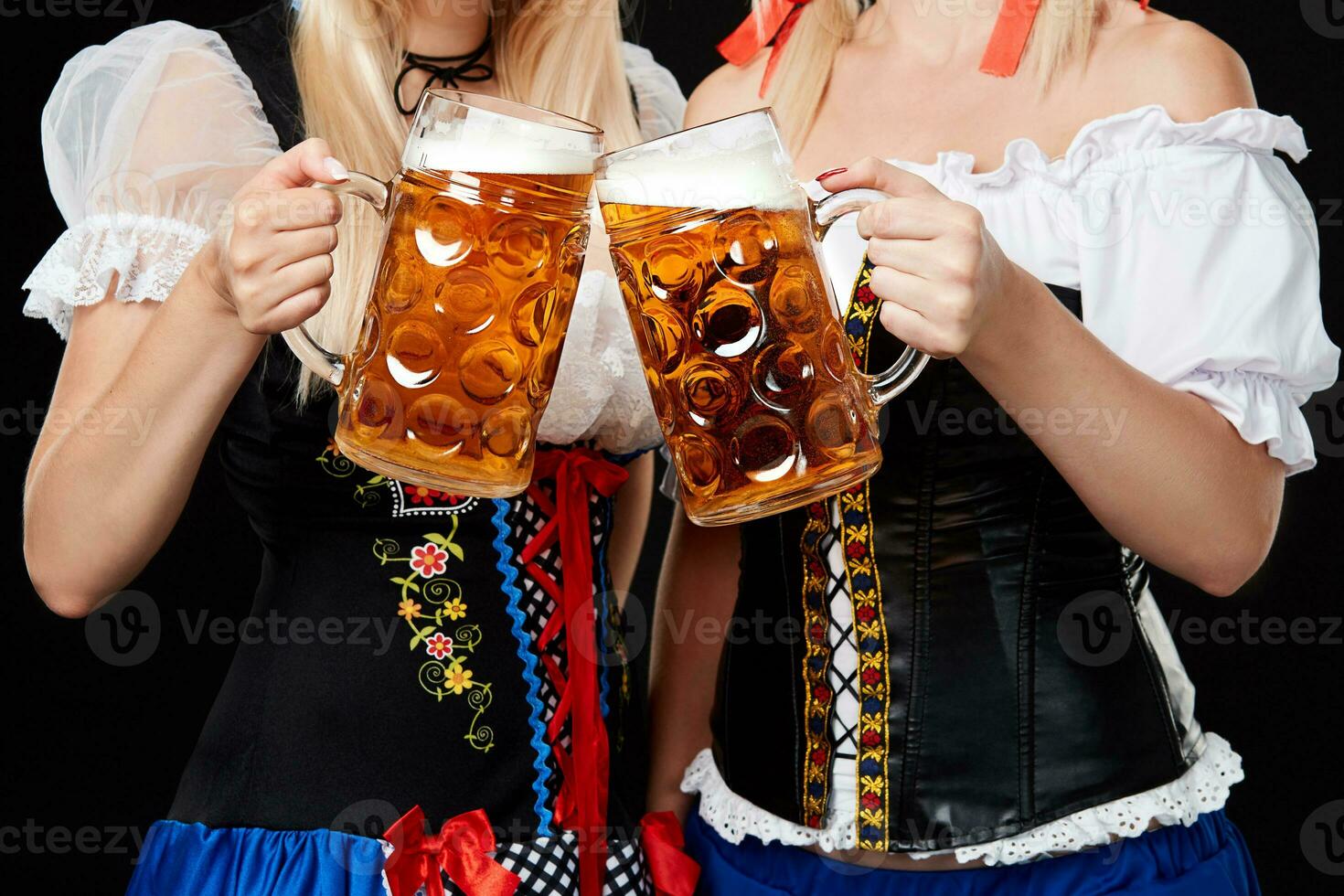 jung und schön bayerisch Mädchen mit zwei Bier Tassen auf schwarz Hintergrund foto