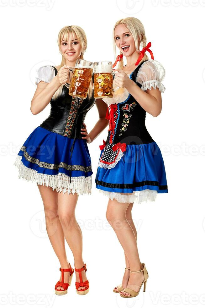 voll Länge Porträt von ein zwei blond Frauen mit traditionell Kostüm halten Bier Brille isoliert auf Weiß Hintergrund. foto