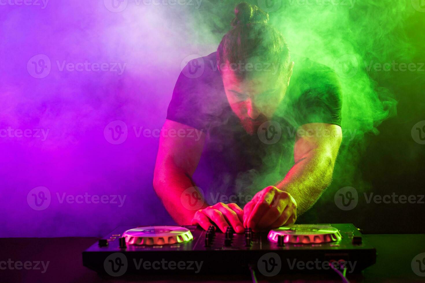 attraktiv jung dj spielen auf Plattenspieler mit Farbe Licht Auswirkungen foto