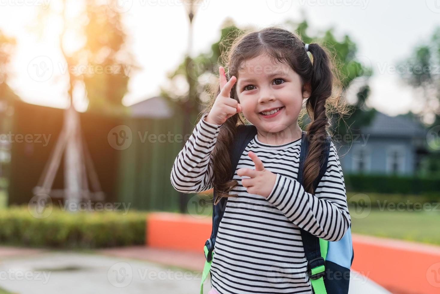 glückliches kleines Mädchen geht gerne zur Schule. zurück zum Schul- und Bildungskonzept. glückliches Leben Familie Lifestyle-Thema. Aufmunternde Geste foto