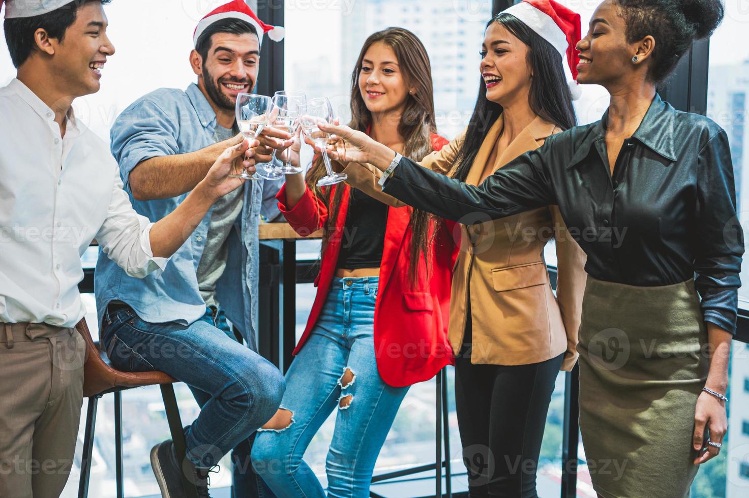 Gruppe von Business-Diversity-Kollegen, die für Silvesterparty im modernen städtischen Bürohintergrund feiern. Freunde, die gemeinsam eine Party mit alkoholischen Getränken genießen. multiethik menschen lebensstil foto