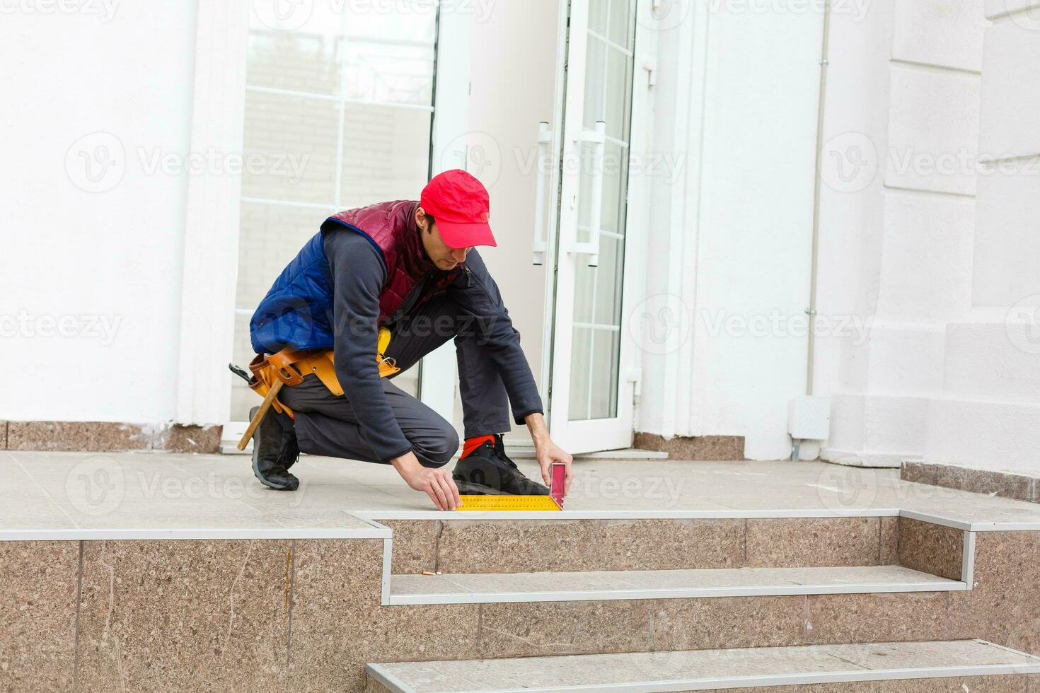 ein Arbeiter installiert Paneele Beige Abstellgleis auf das Fassade von das Haus foto