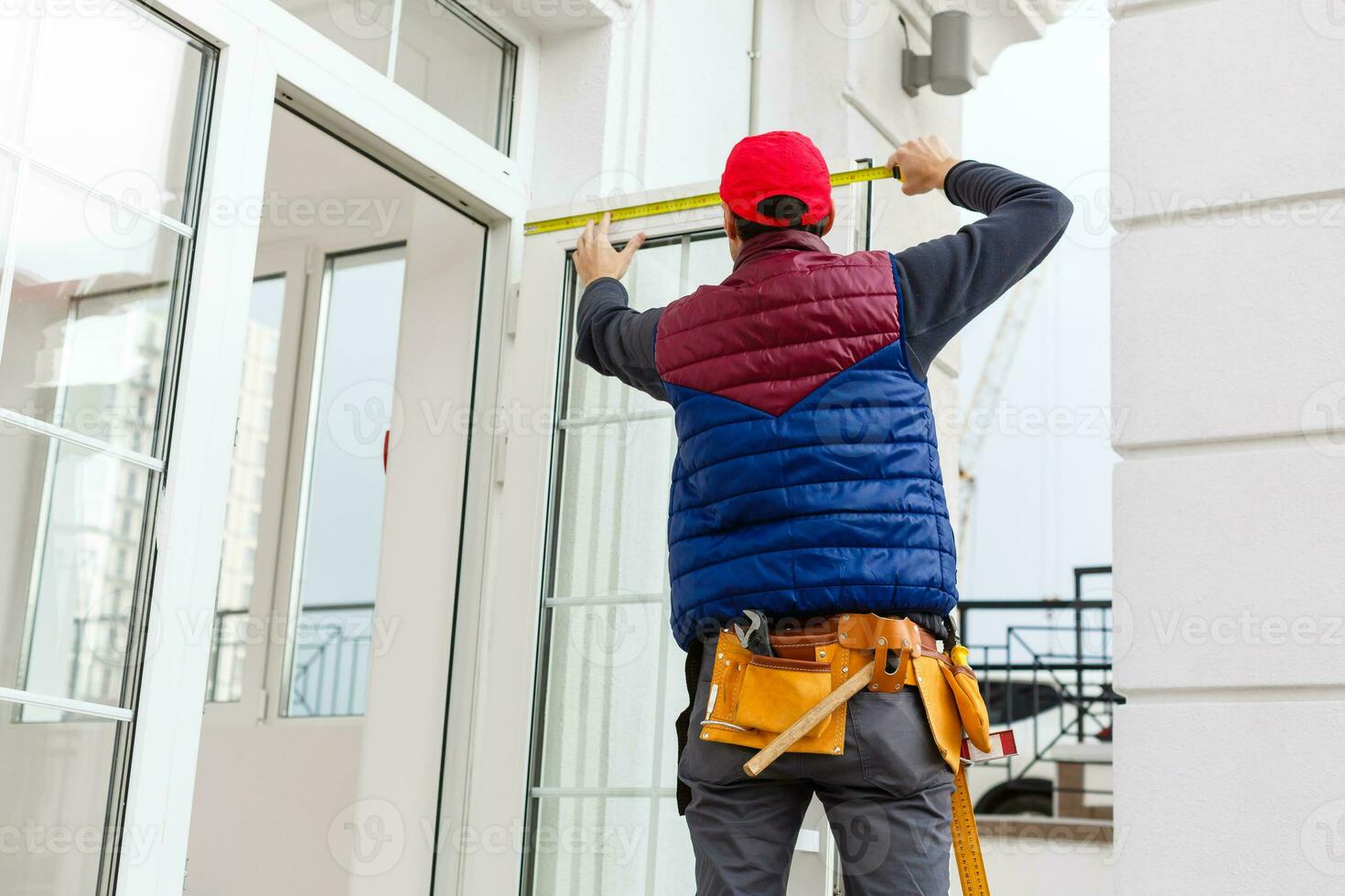 ein Arbeiter installiert Paneele Beige Abstellgleis auf das Fassade von das Haus foto