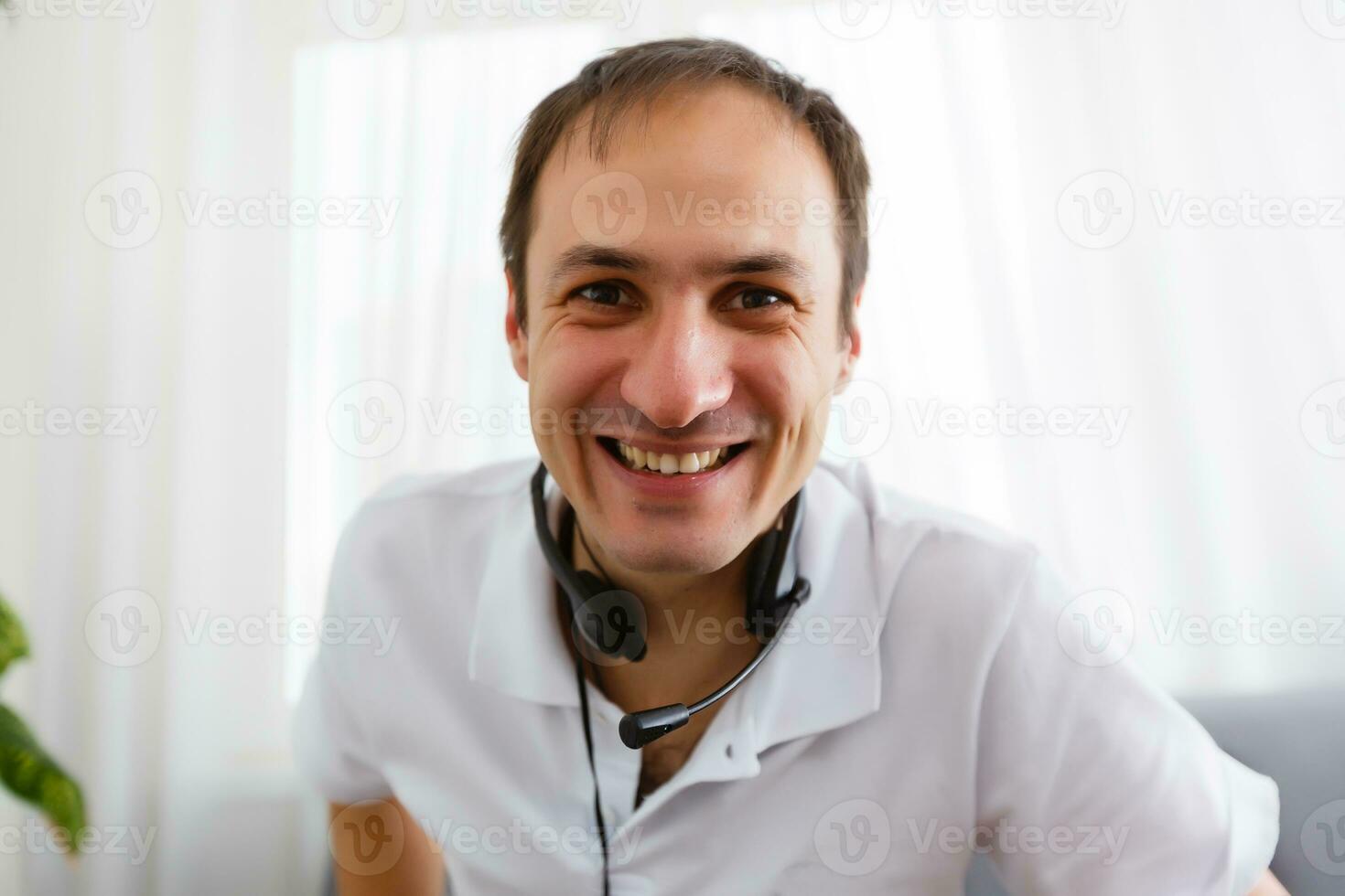 Porträt von glücklich reifen Mann Herstellung Hand Gesten während unterhalten mit ein Video Anruf beim Laptop mit Kopfhörer. heiter beiläufig Geschäftsmann tun Video Berufung beim heim. foto