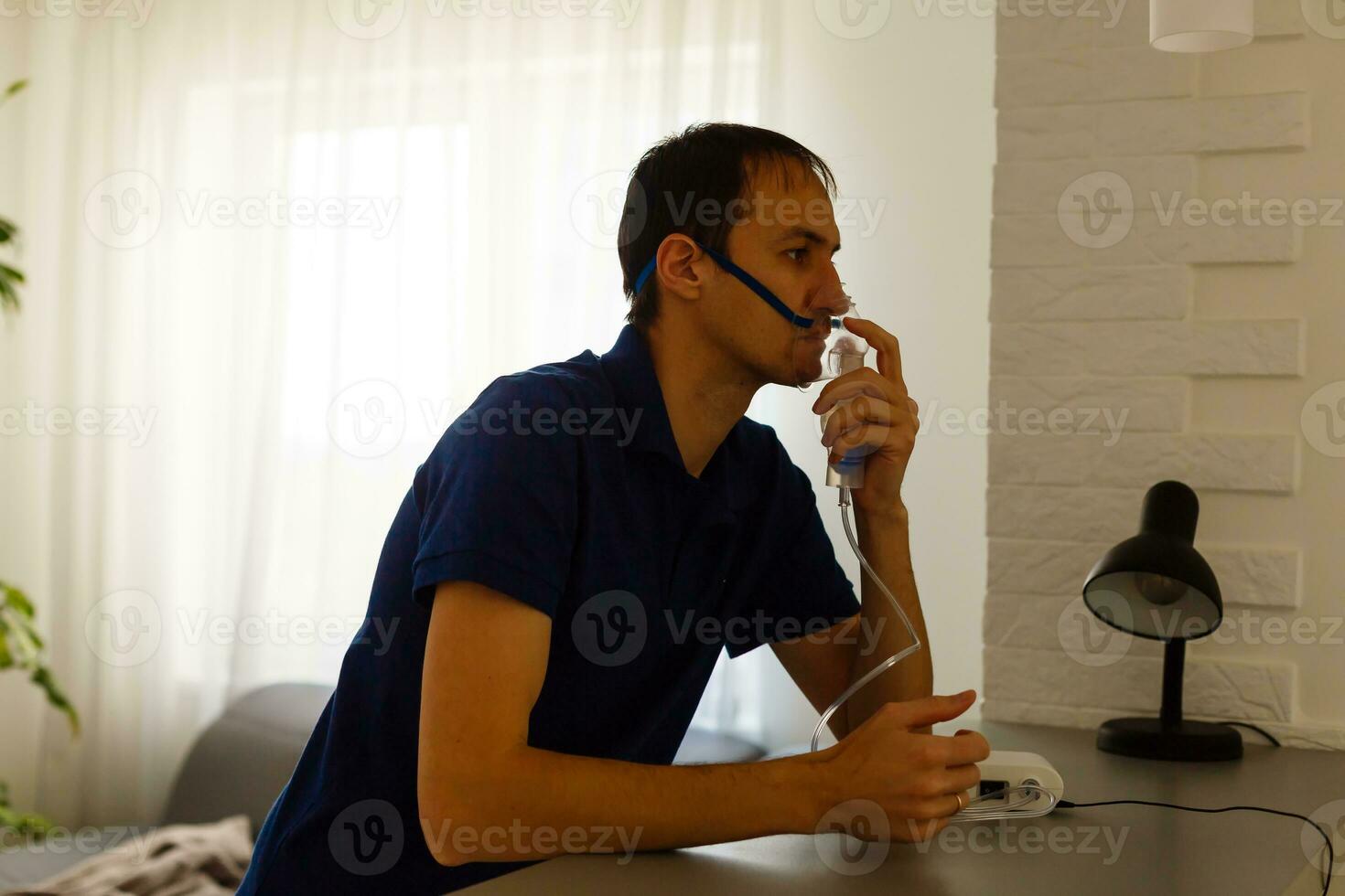 Porträt von jung Mann Einatmen durch Inhalator Maske foto