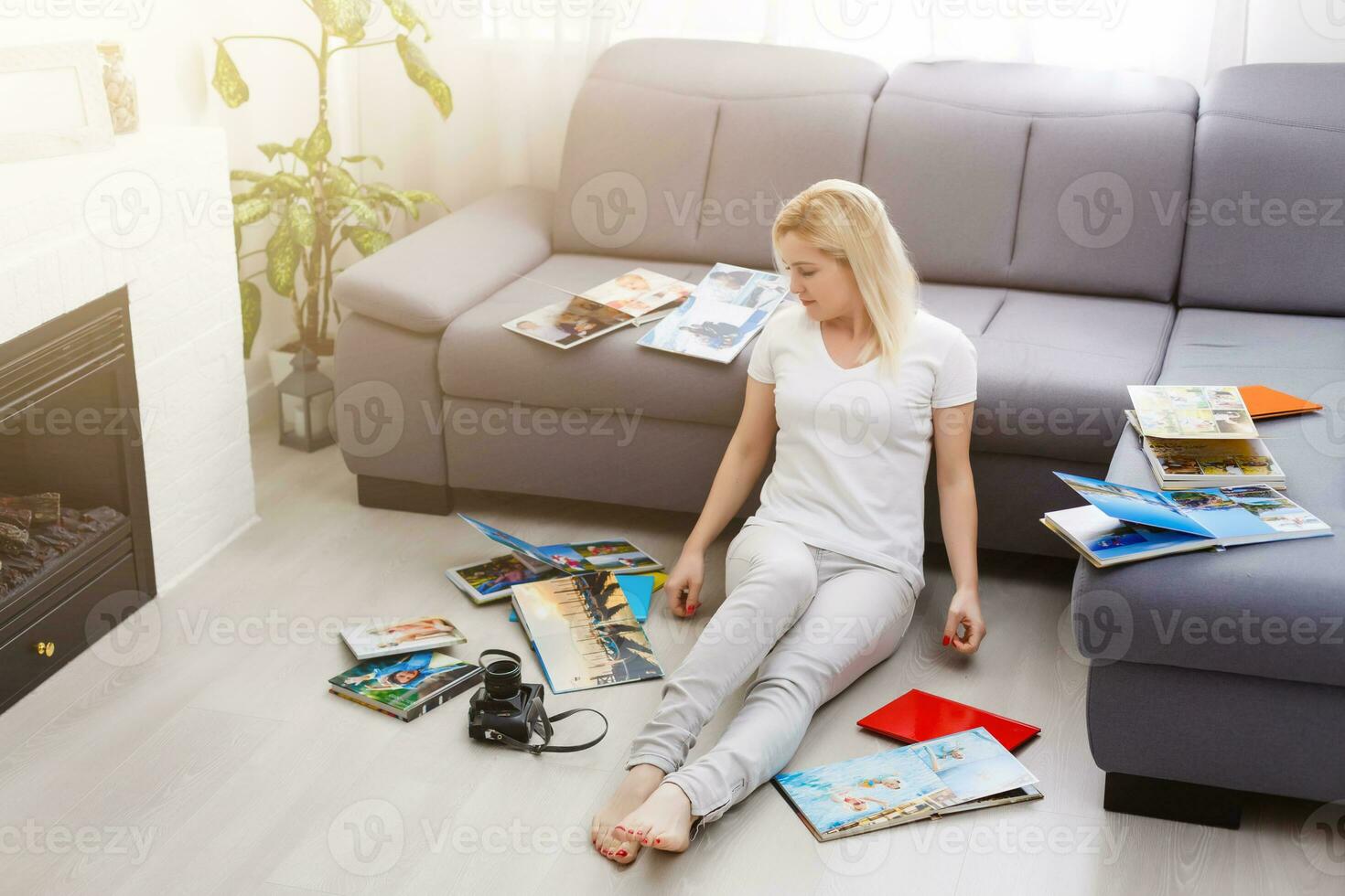 jung glücklich Frau suchen beim Fotobuch im ihr Zimmer foto