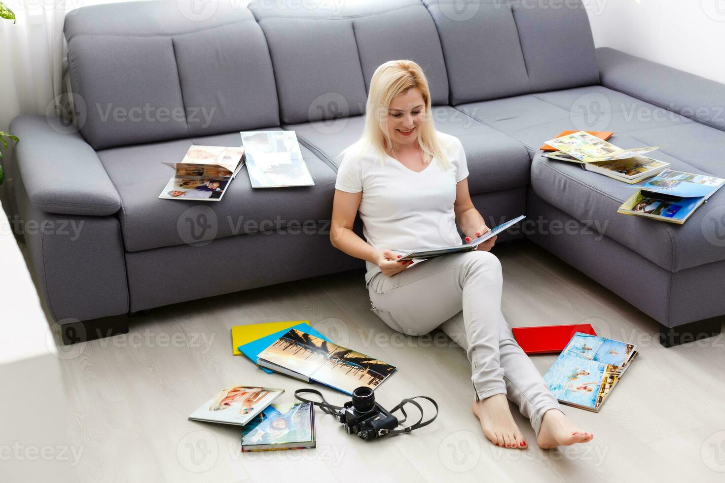 jung glücklich Frau suchen beim Fotobuch im ihr Zimmer foto