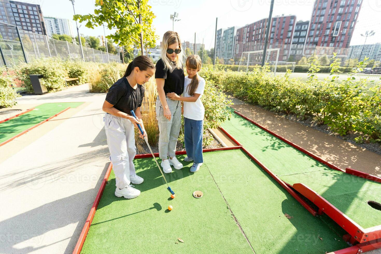 Gruppe von zwei komisch Kinder spielen Mini Golf, Kinder genießen Sommer- Ferien foto