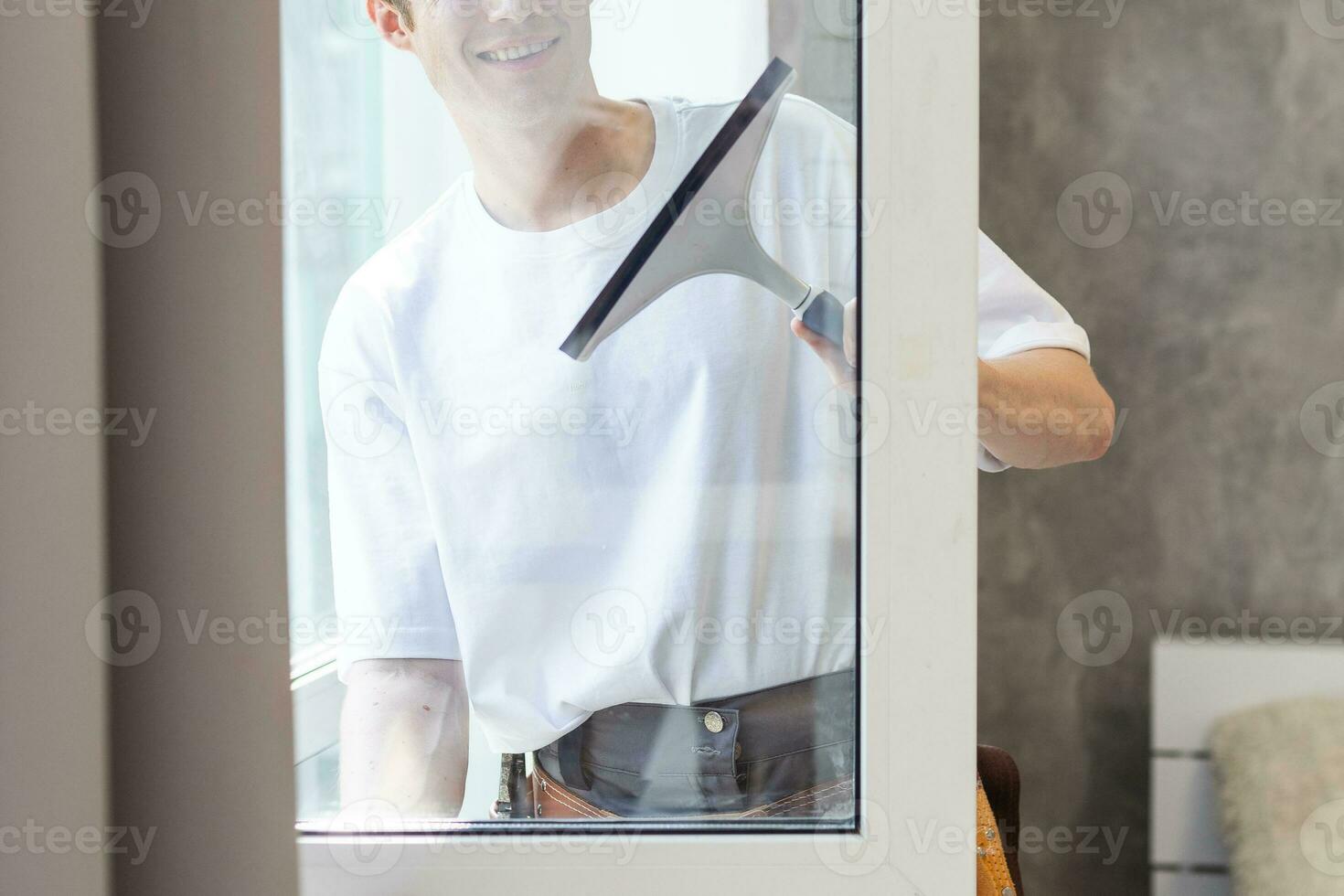 jung Mann Reinigung Fenster im das Haus foto