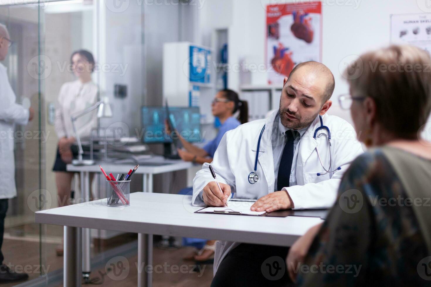 Spezialist Arzt verschreiben Behandlung zum Senior Frau Schreiben auf Zwischenablage. älter geduldig Besuch Arzt erzählen Über Gesundheit Beschwerden, medizinisch Praktiker fragen Fragen reden Über Füllung Krankheit. foto