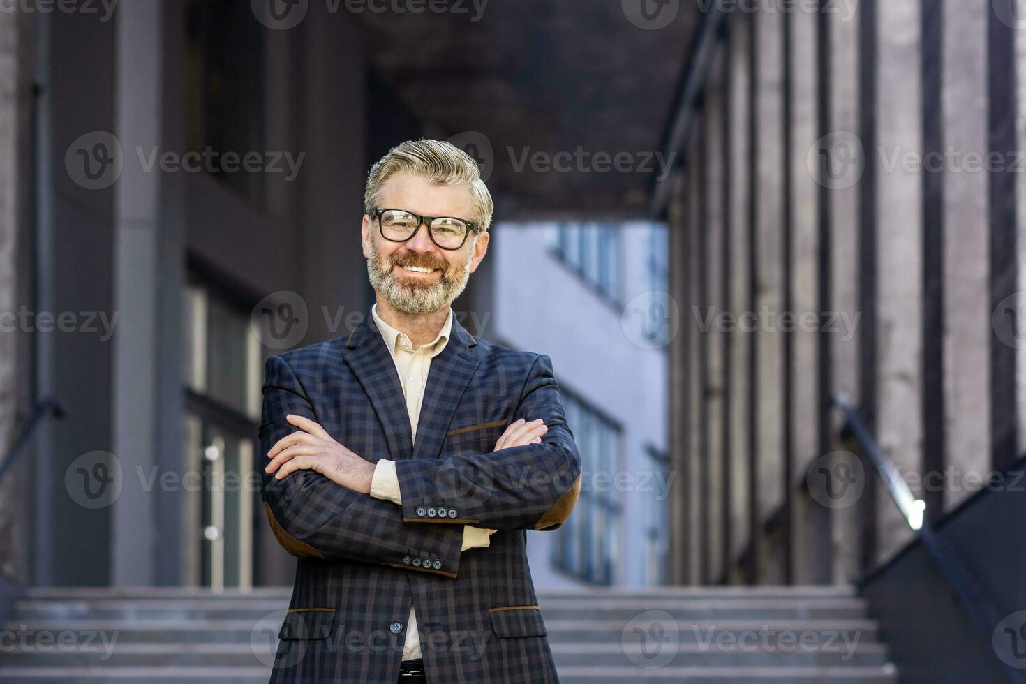 Porträt von reifen grau haarig Geschäftsmann, Senior Boss lächelnd und suchen beim Kamera mit Waffen gekreuzt, grau haarig Mann draußen Büro Gebäude, erfolgreich Investor und Inhaber im Geschäft passen foto