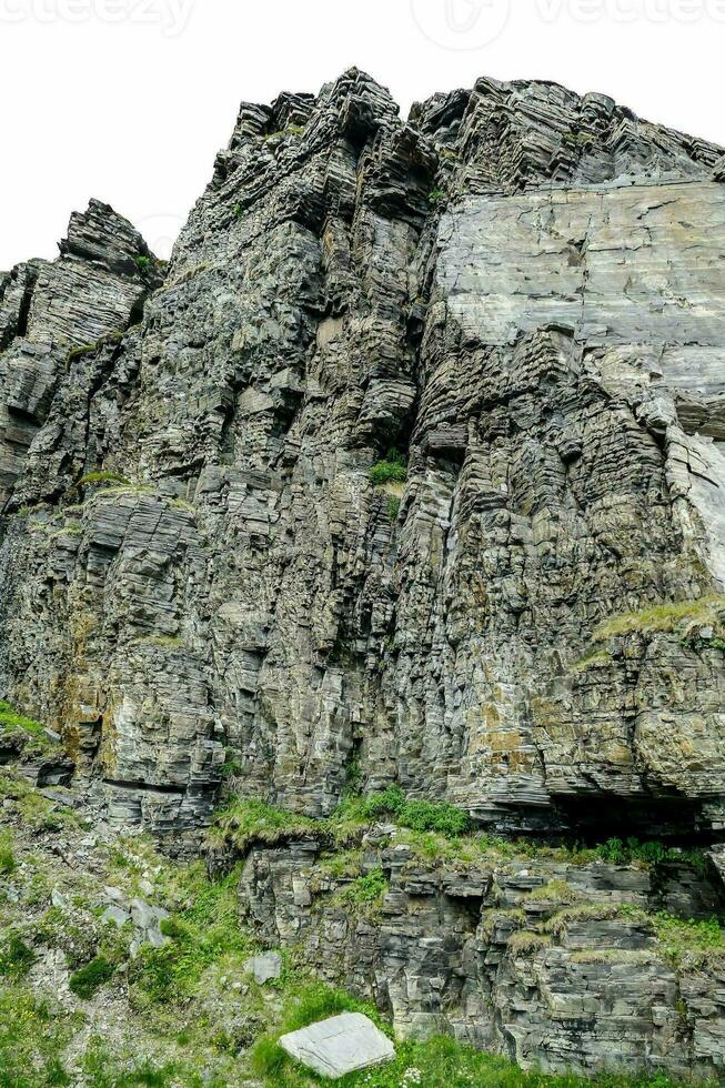 ein groß Felsen Formation auf das Seite von ein Berg foto