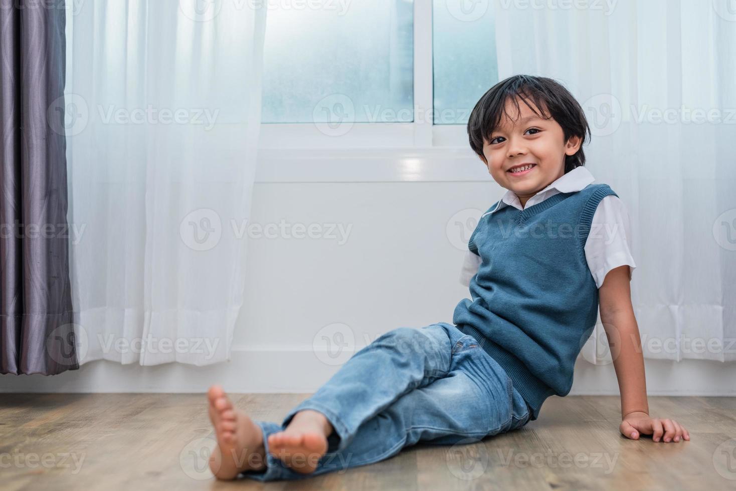 glücklicher Junge, der im Schlafzimmer sitzt und lächelt. Lebensstile und Menschenkonzept. Porträt- und Glückslebenskonzept. Zuhause süßes Zuhause Thema foto