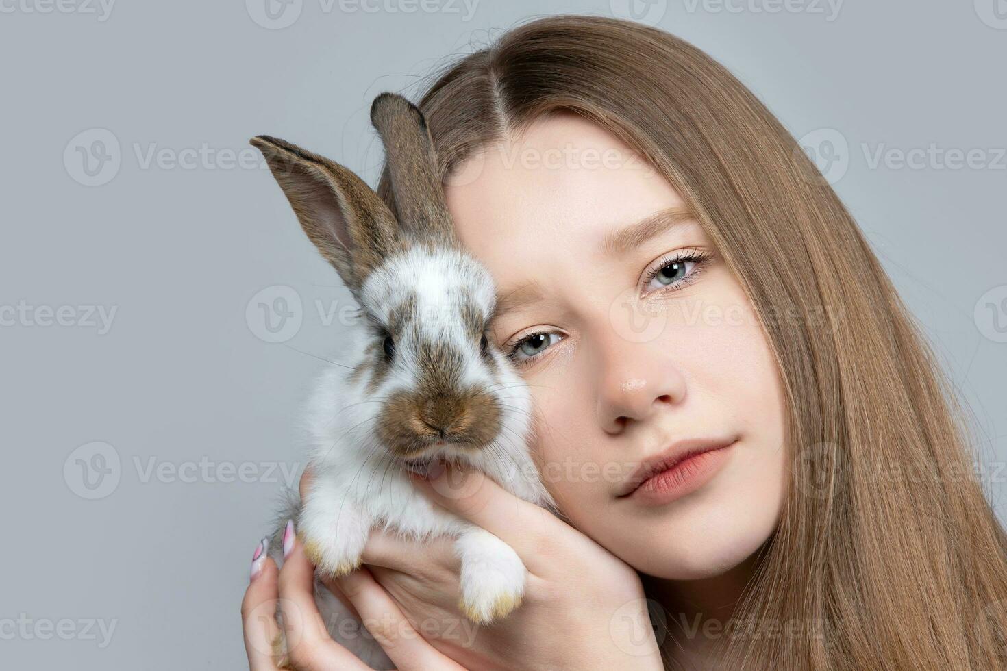 ein Teenager Mädchen mit blond Haar hält ein pockennarbig Hase. foto