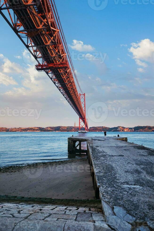 Aussicht von 25 de Abril Brücke Über Tagus Fluss, Christus das König Monument und ein Kai. Lissabon, Portugal foto