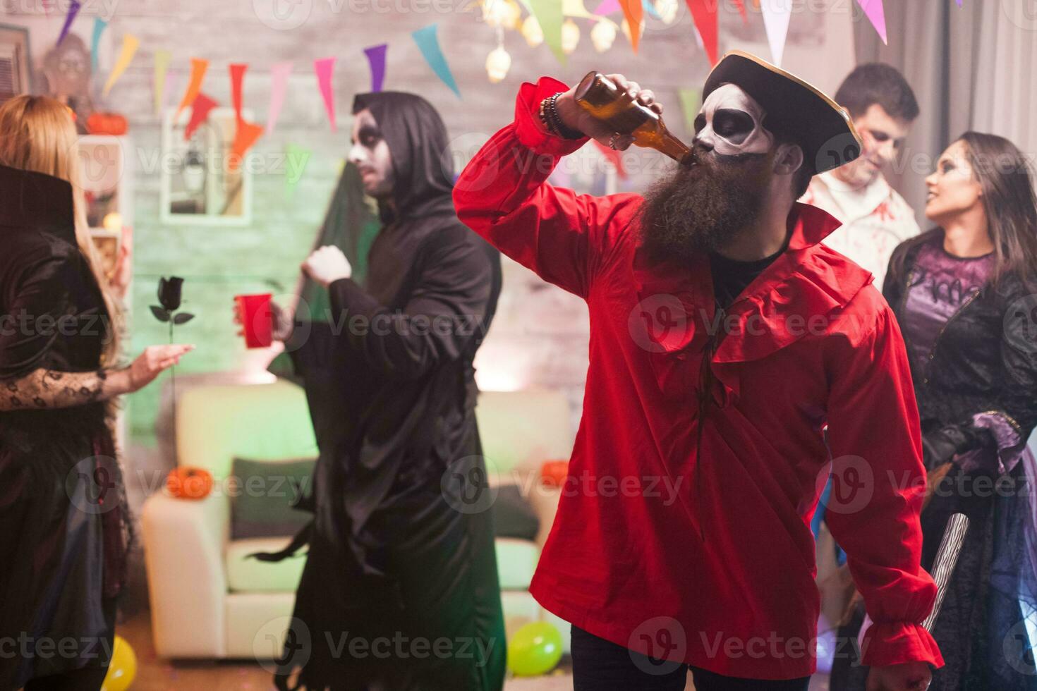 Mann gekleidet oben mögen ein mittelalterlich Pirat Trinken Bier beim Halloween Feier. foto