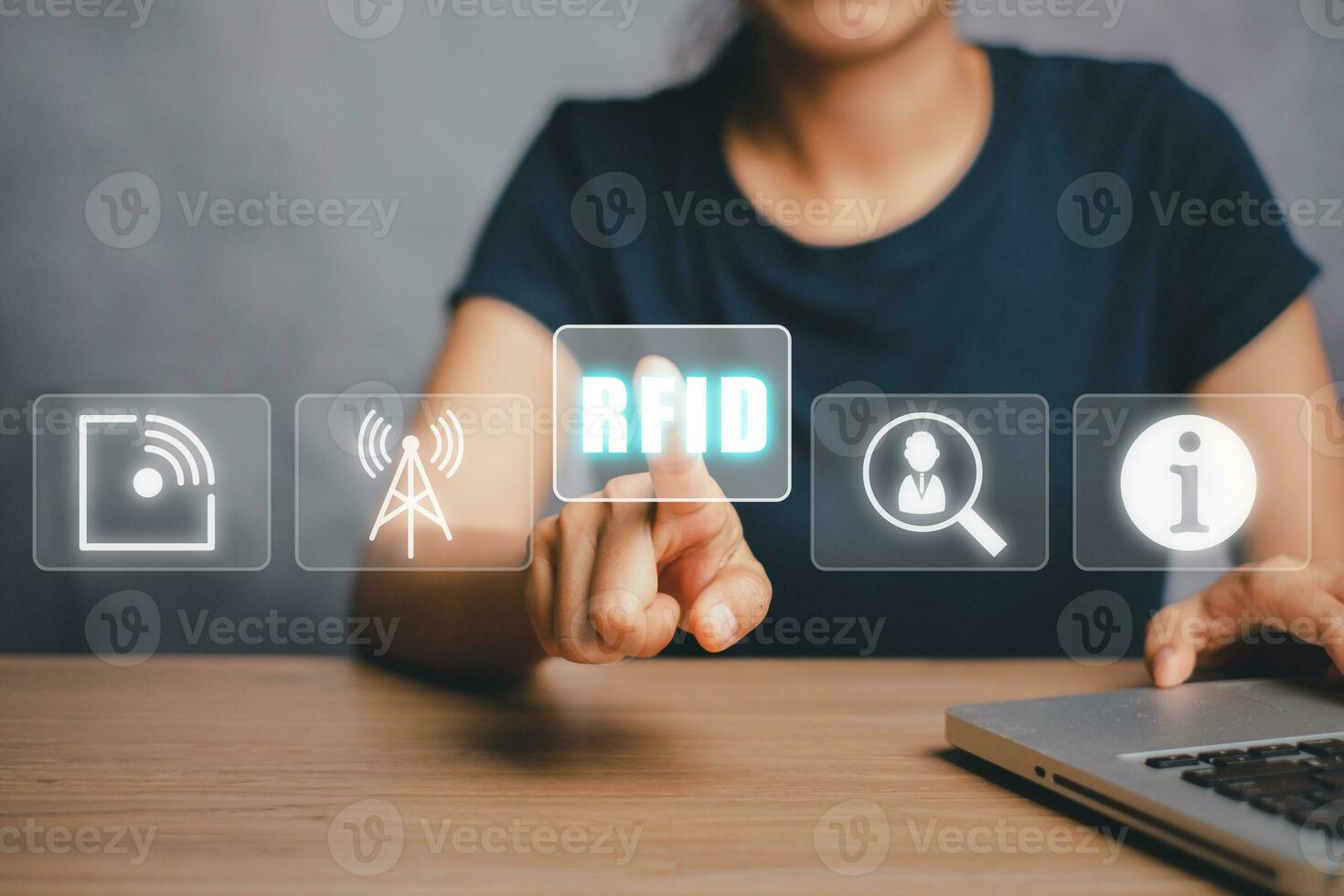 rfid, funkfrequenzidentifikationskonzept, person, die einen laptop verwendet und das rfid-symbol auf dem virtuellen bildschirm mit der hand berührt. foto