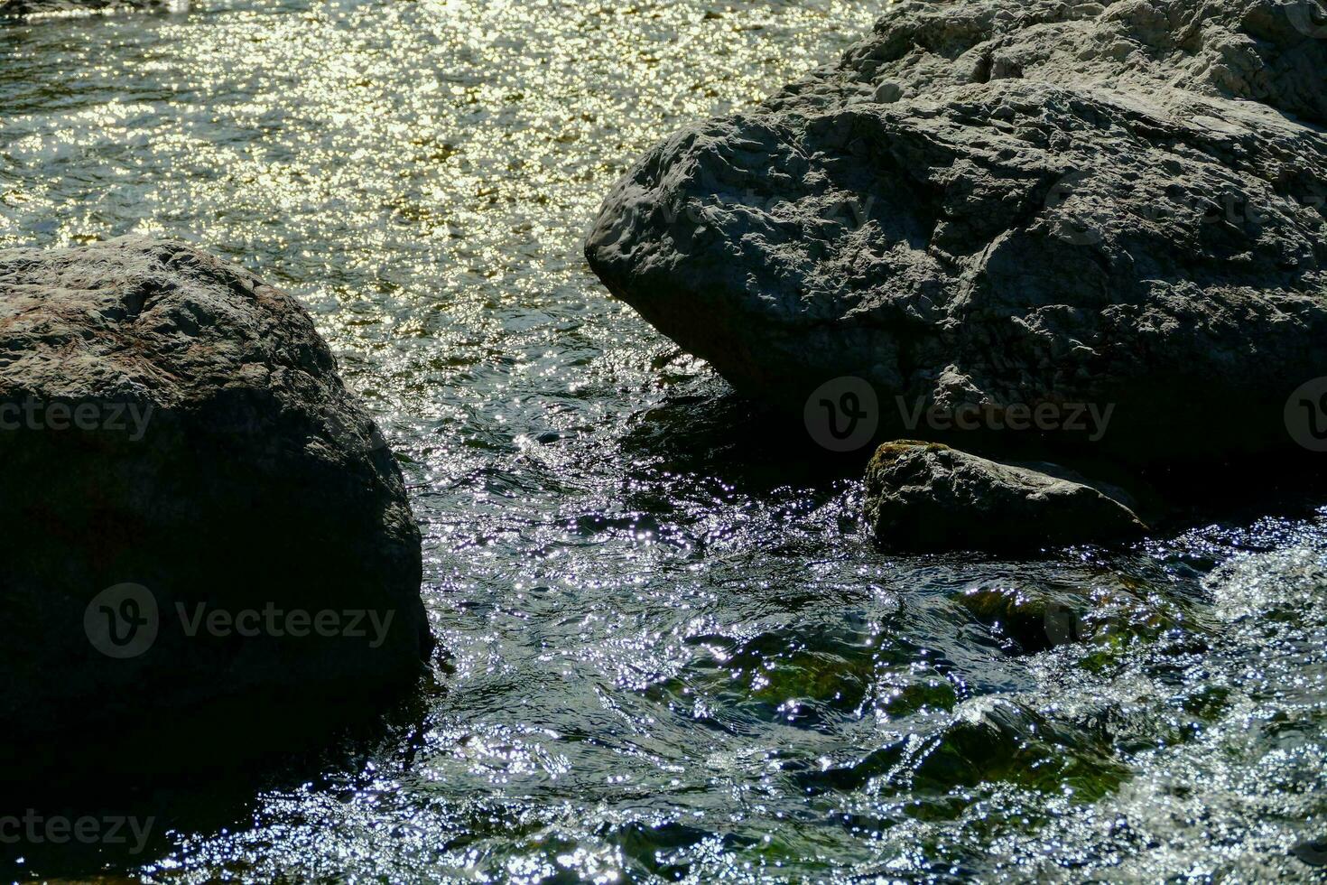 ein Fluss mit Felsen und Wasser fließend Über Sie foto