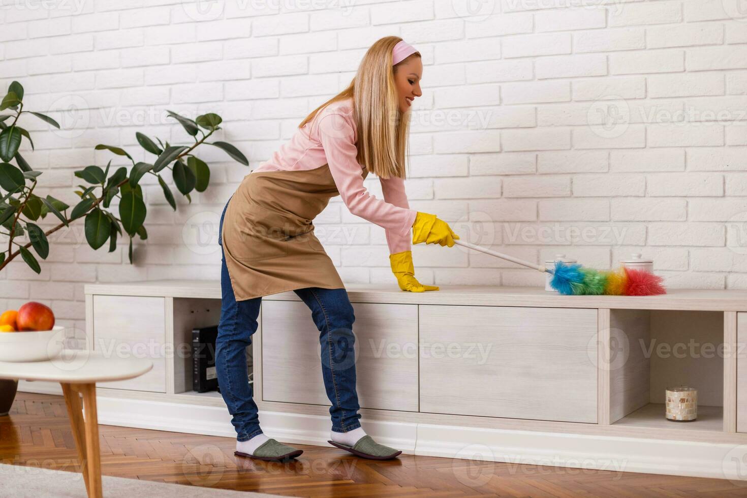 schön Hausfrau genießt Reinigung mit Staubtuch ihr heim. foto