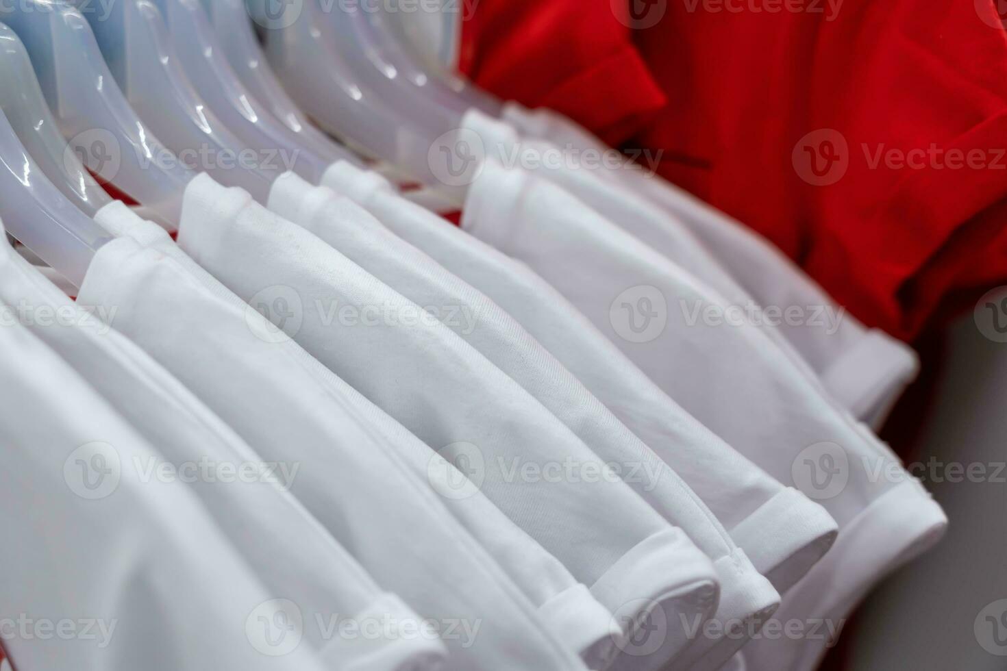stilvoll Weiß T-Shirts hängend auf Kleiderbügel im Mode Geschäft Anzeige foto