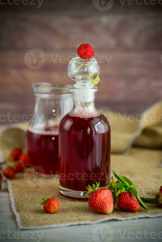 Süss gekocht Erdbeere Sirup im ein Glas Karaffe foto
