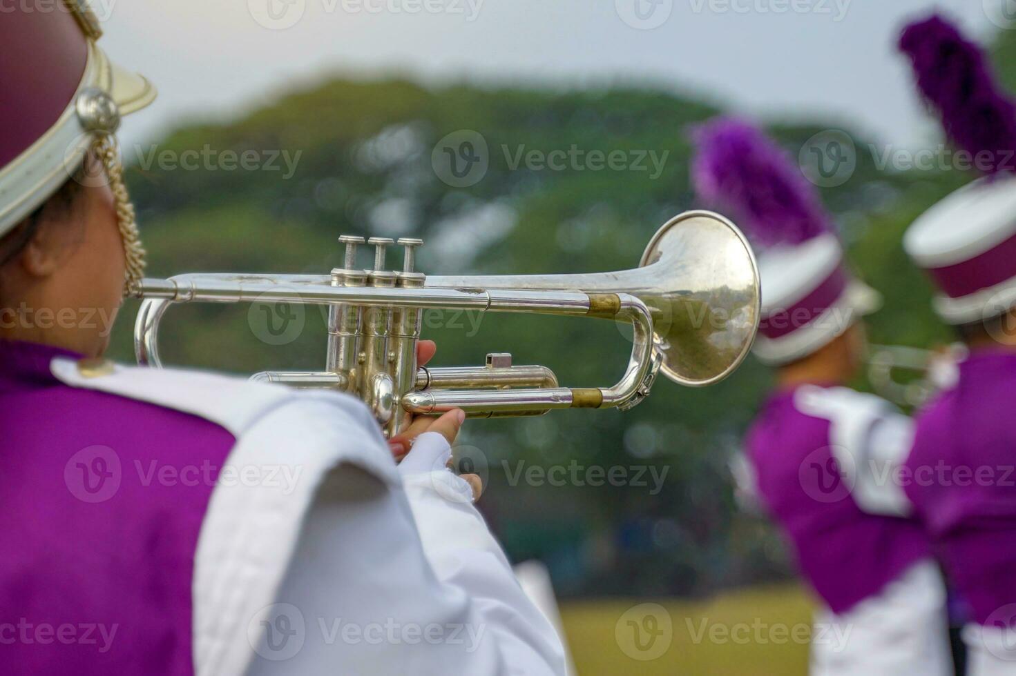 Nahansicht von Studenten Hand drücken das Taste von ein Trompete zu Verfolgungsjagd ein Musical Notiz, spielen ein Lied während üben zum ein Schule Parade. Sanft und selektiv Fokus. foto