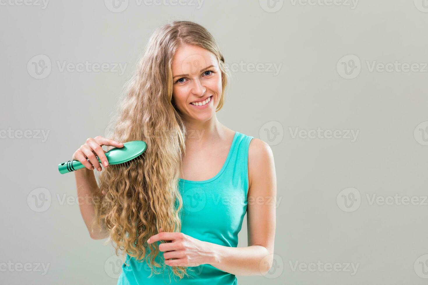 jung Frau Bürsten ihr Herrlich lange blond Haar. foto
